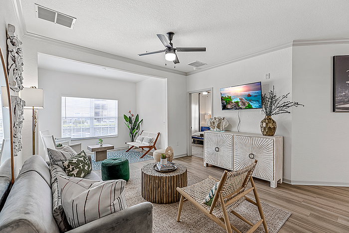 Charming and modern living room with elegant decor, featuring a cozy seating area, stylish wooden accents, and natural light flowing through a large window.