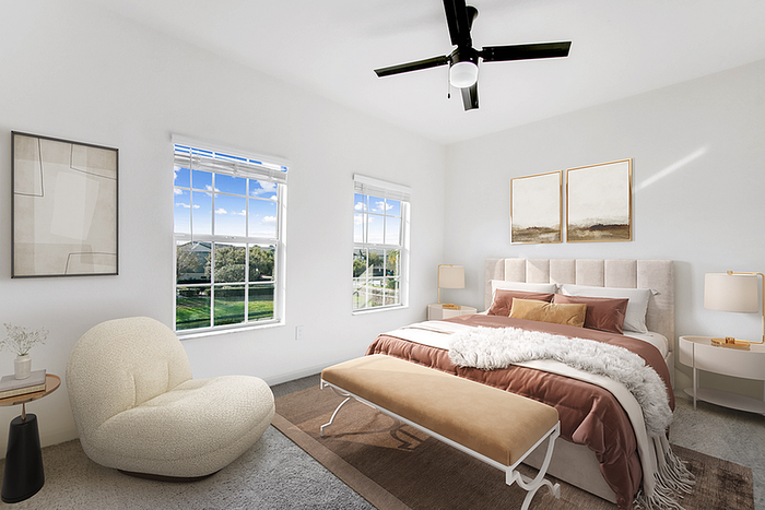 Bright and airy bedroom with elegant decor, a plush bed, and panoramic windows offering a stunning view of greenery.