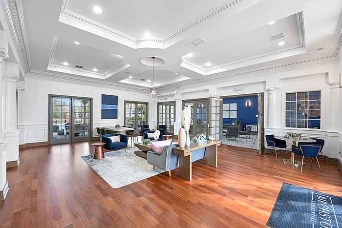 Elegant clubhouse space with modern decor and rich hardwood floors featuring stylish seating and abundant natural light.