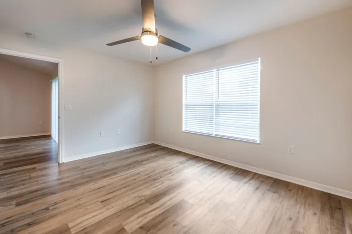 Newly renovated bedroom with natural lighting, a ceiling fan, and a generous closet.