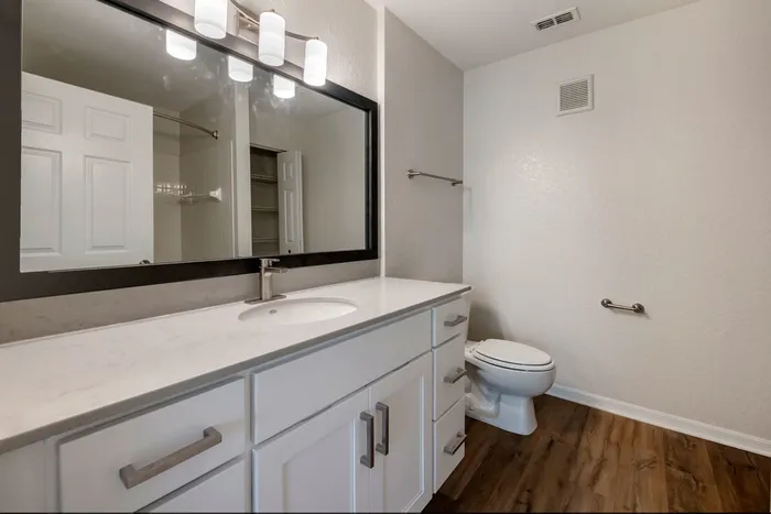 Newly renovated bathroom with ample storage, a shower/tub combo, and large countertops.