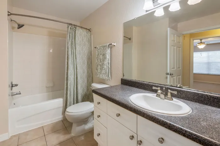 Spacious bathroom with ample storage, a shower/tub combo, and large countertops.