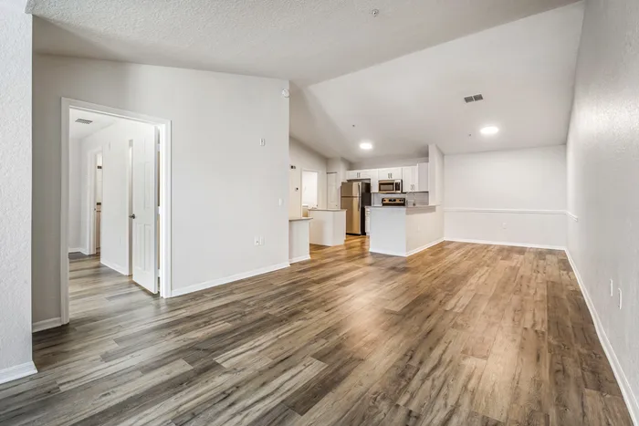 Spacious living room with ample room for seating, natural sunlight, and modern finishes.