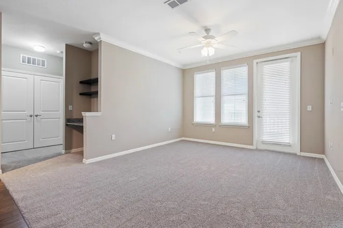 Carpeted living room with access to a balcony and two large windows at Lantower Asturia.