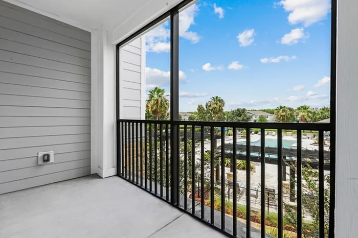 Balcony with a view of the resort-style pool and palm trees at Lantower Asturia.