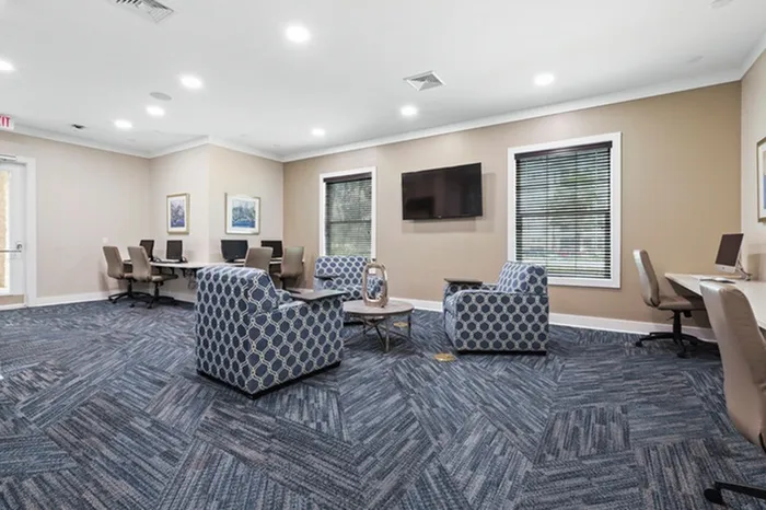 Cybercafe with carpet floors, iMac computers, and Windows stations Resort-style pool with sundeck and lounge chairs at Lantower Asturia.