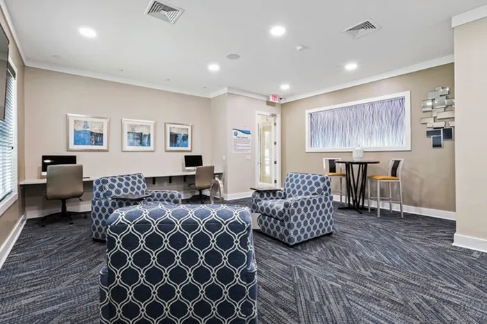 Cybercafe with carpet floors, iMac computers, and Windows stations Resort-style pool with sundeck and lounge chairs at Lantower Asturia.