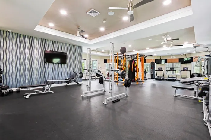 Fully Equipped Fitness Studio featuring Crossfit Box with large ceiling fans and large windows, and wall mounted TVs Resort-style pool with sundeck and lounge chairs at Lantower Asturia.