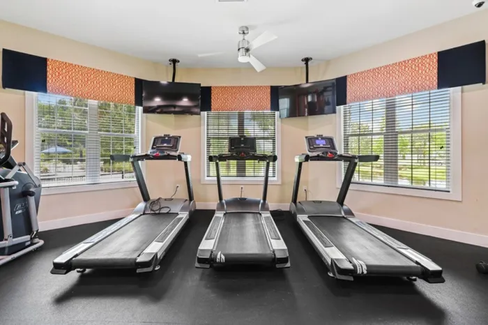 Fully Equipped Fitness Studio with treadmills and ample natural light from large windows Resort-style pool with sundeck and lounge chairs at Lantower Asturia.