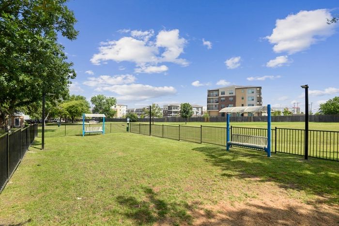 Spacious outdoor area with grass and benches at Lantower Round Rock