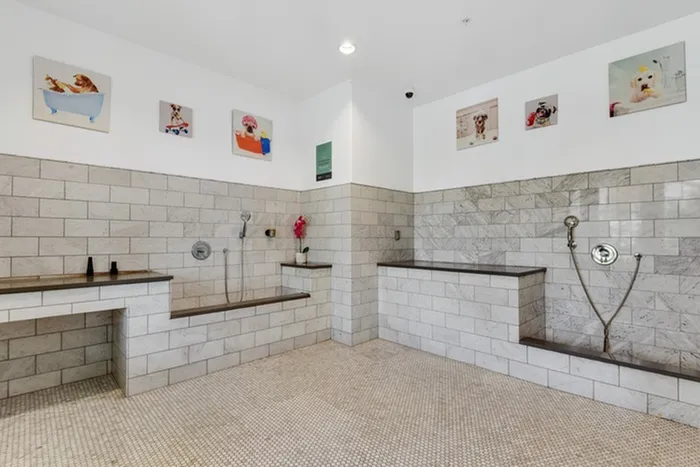 Dog, cat, and pet spa and washing equipped with tiled showers and mosaic flooring at Lantower Ambrosio Apartments
