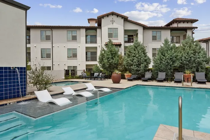 Resort-style pool with ample relaxing seating at Lantower Ambrosio Apartments.