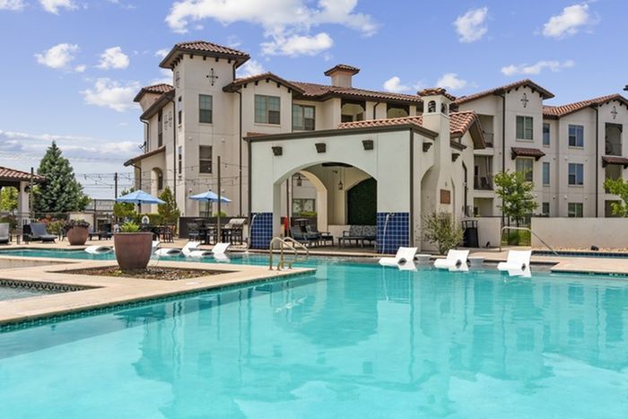 Resort-style pool with a shaded lounge area, deck and ample relaxing seating at Lantower Ambrosio Apartments.
