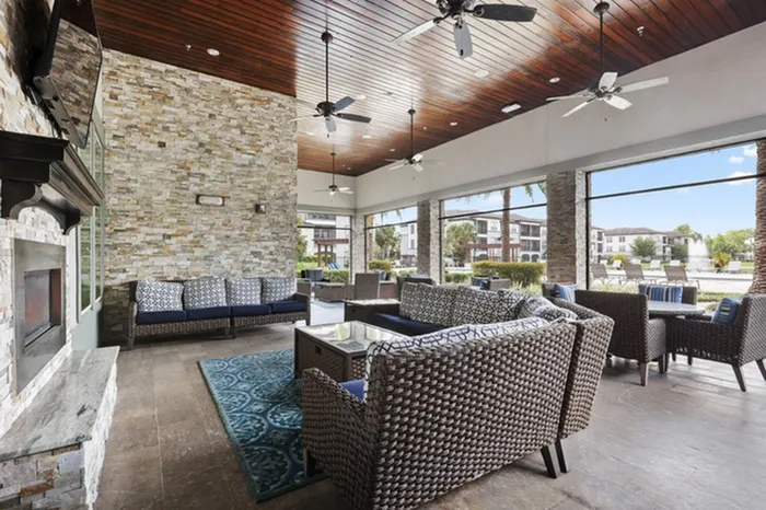 Spacious, covered veranda with natural sunlight, a fireplace, and stylish furniture at Lantower Grande Pines.