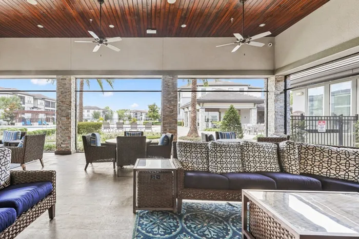 Spacious, covered veranda with natural sunlight, a fireplace, and stylish furniture at Lantower Grande Pines