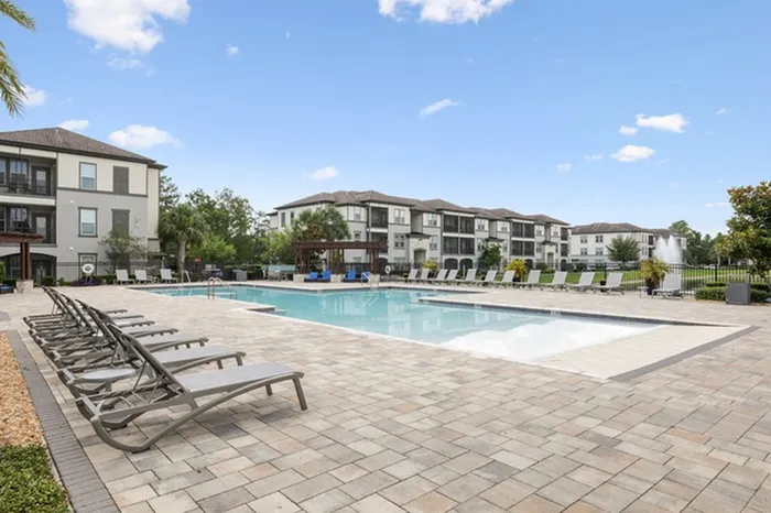 Resort-style pool with sundeck and lounge chairs at Lantower Grande Pines.