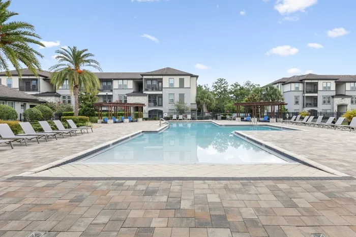 Resort-style pool with sundeck and lounge chairs at Lantower Grande Pines