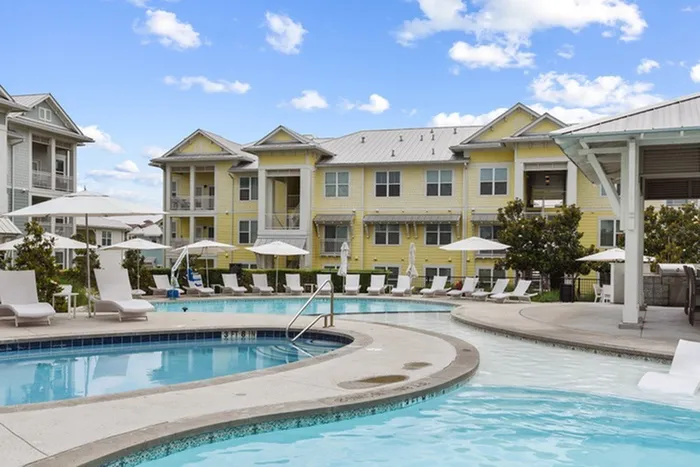 Large pool and kiddie pool accompanied by pool chairs and pool umbrellas at Lantower Edgewater