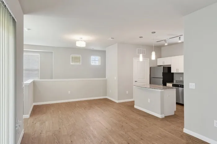 Kitchen and dining room with faux wood flooring, granite countertops, and Maytag stainless steel appliances at Lantower Edgewater