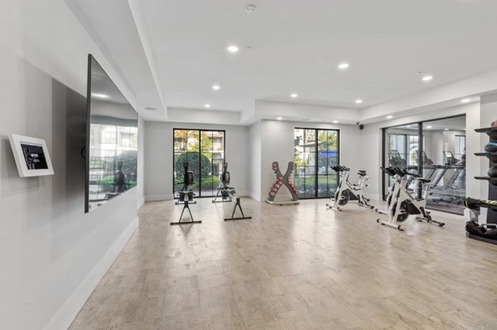 24-Hour Fitness Center with Yoga Room & Fitness On-Demand with wooden floors and floor-to-ceiling windows at Lantower Grande Flats Apartments.