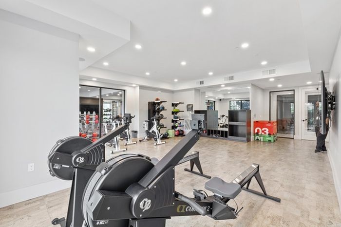 24-Hour Fitness Center with Yoga Room & Fitness On-Demand with wooden floors gym equipment at Lantower Grande Flats Apartments.