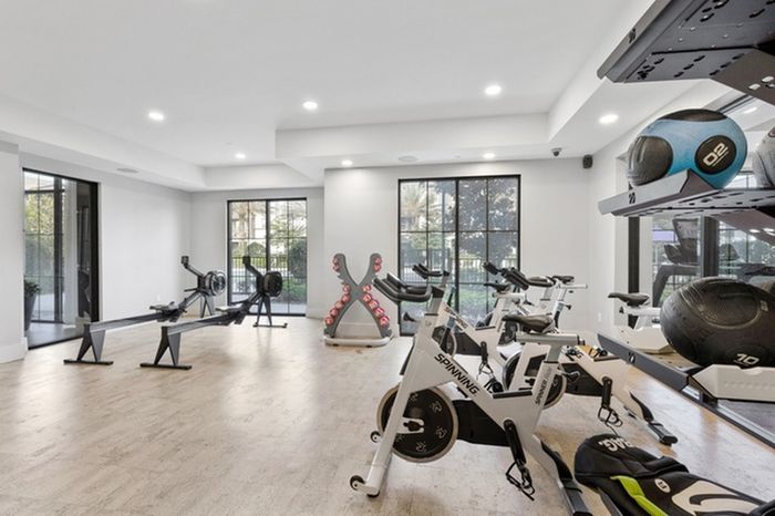 24-Hour Fitness Center with Yoga Room & Fitness On-Demand with wooden floors and floor-to-ceiling windows at Lantower Grande Flats Apartments.