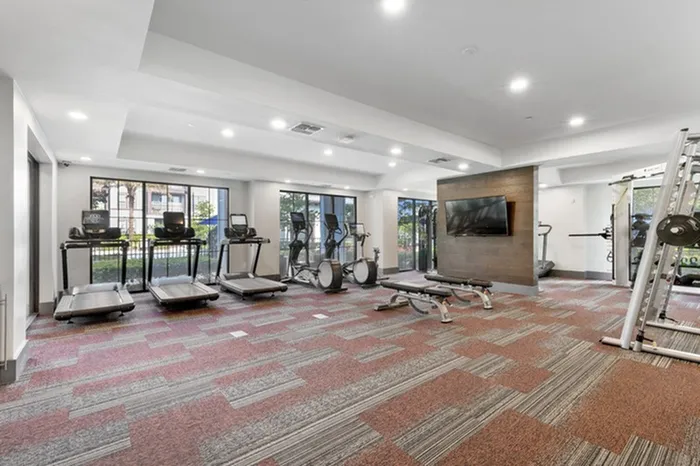 24-Hour Fitness Center with floor-to-ceiling windows at Lantower Grande Flats Apartments.