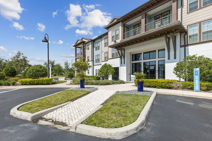 Welcome center with landscaped shrubs lining the entrance at Lantower Grande Flats Apartments.