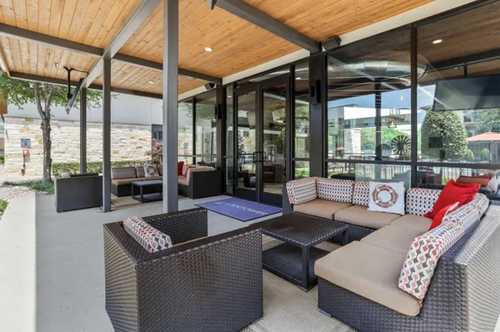 Outdoor lounge area with wood-style awning, padded outdoor furniture, and plenty of pillows at Lantower Legacy Lakes