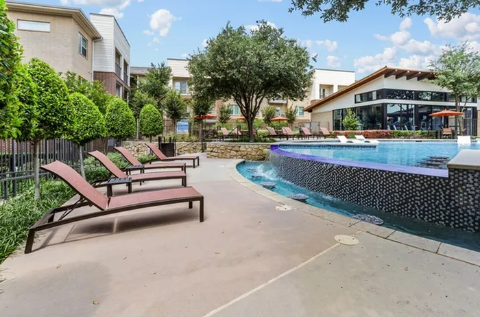 Pool chairs next to swimming pool with a vanishing edge at Lantower Legacy Lakes