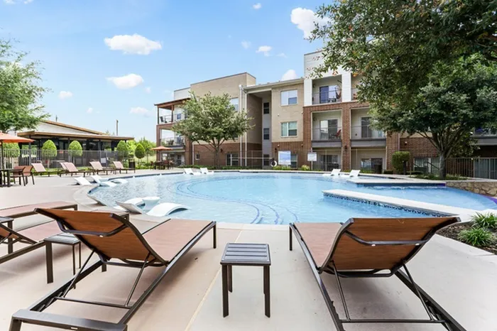 Pool chairs surrounding swimming pool at Lantower Legacy Lakes