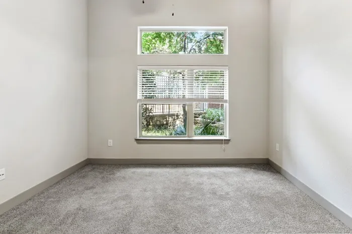 Bedroom with carpet flooring, and large square window providing natural light at Lantower Legacy Lakes