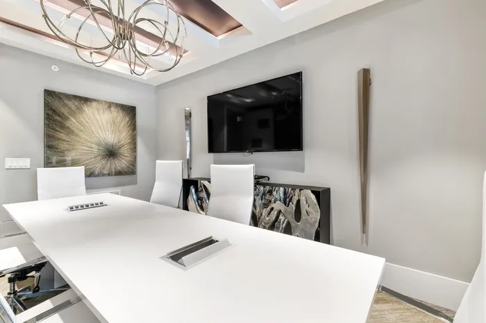 Conference center with modern furniture and a wall mounted TV at Lantower Weston Corners.