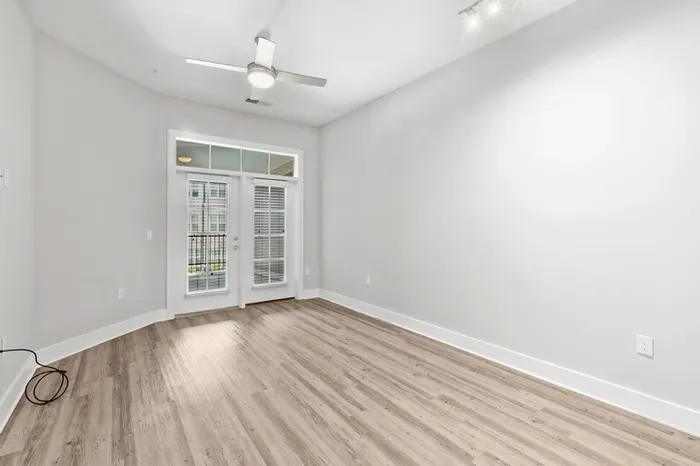 Room at Lantower Weston Corners with large French-style doors with windows above them and wood-style floors.