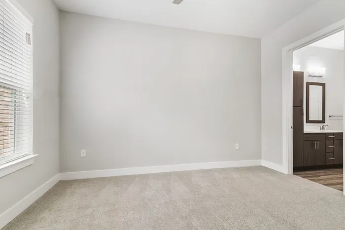 Spacious living room with a ceiling fan, wood-style floors, and a sliding glass door to a balcony at Lantower Weston Corners.