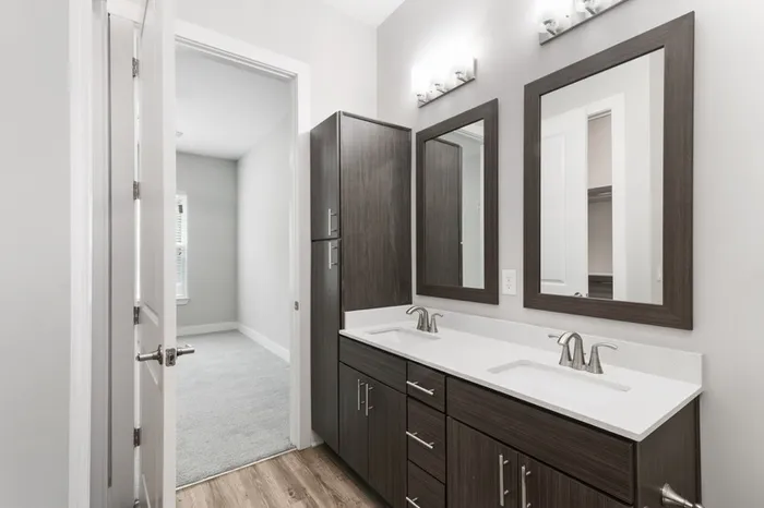 Modern bathroom with dark-colored cabinetry, quartz countertops, 10-foot ceilings, and silver hardware at Lantower Weston Corners.
