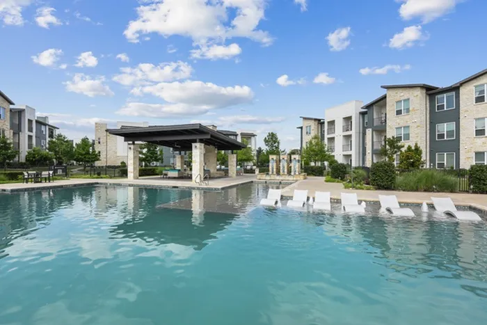 Resort-style swimming pool with a sunny deck, ample relaxing seating including in pool relaxation at Lantower Techridge apartments