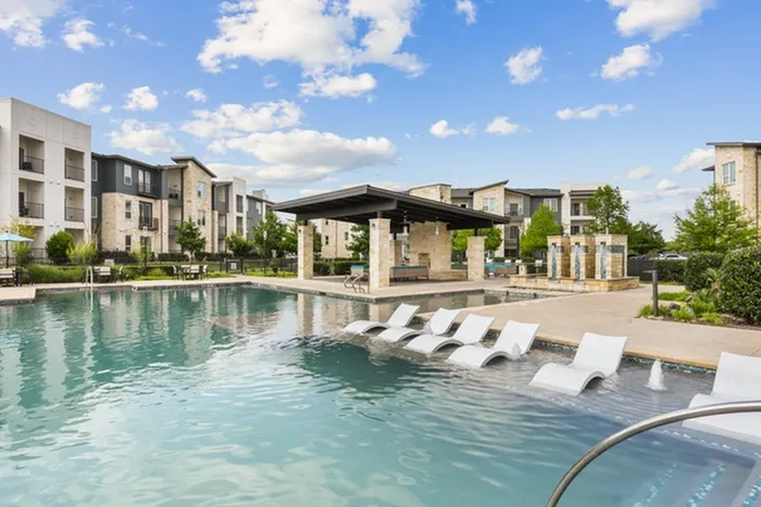 Resort-style swimming pool with a sunny deck, ample relaxing seating including in pool relaxation at Lantower Techridge apartments