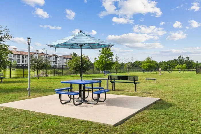 Luscious grass dog and pet park with ample space for relaxation, suited with a park bench and equipment for dogs at Lantower Techridge apartments