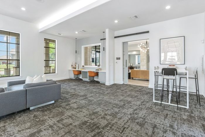 Modern lounge space with cozy sofas, elevated seating with modern stools, desk space and beautiful natural lighting at Lantower Residences at the Collection