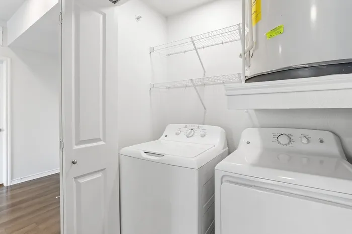 Individual white washer and dryer machine at Lantower Residences at the Collection