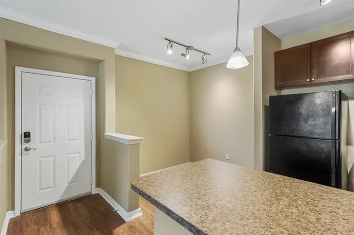 Image of the entrance of a Lantower Cypress Creek apartment with a kitchen island and space for a kitchen table.