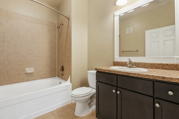 Image of a bathroom with a soaking tub and dark-colored cabinetry at Lantower Cypress Creek.