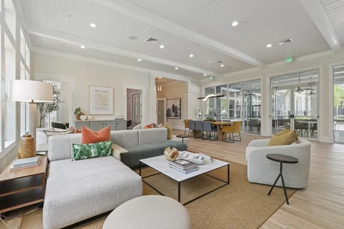 Image of Lantower Cypress Creeks' newly-renovated clubhouse with stylish wallpaper, modern furniture, and ceiling to floor windows with ample natural sunlight.