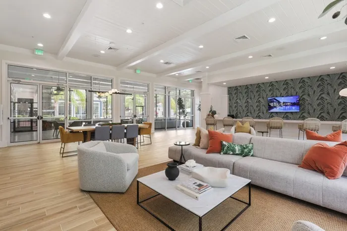 Image of Lantower Cypress Creeks' newly-renovated clubhouse with stylish wallpaper, modern furniture, and ceiling to floor windows with ample natural sunlight.