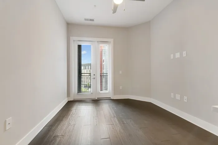 Living room with balcony access and wood-style flooring at Bullhouse.