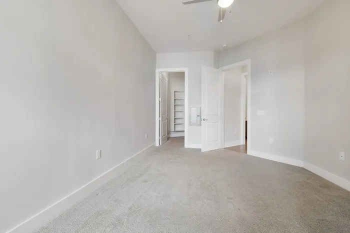Carpeted bedroom with a walk-in closet at Bullhouse.