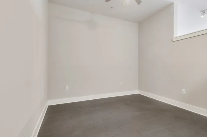 Spacious bedroom with a ceiling fan and wood-style flooring at Bullhouse.