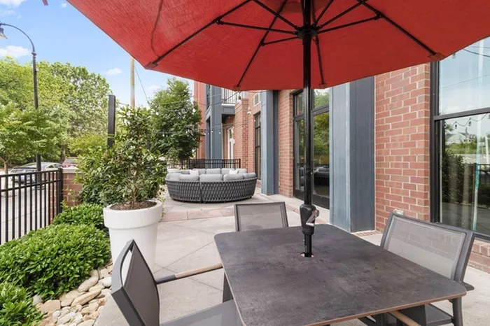 Open patio with umbrellas for shade and a sofa at Lantower Bullhouse