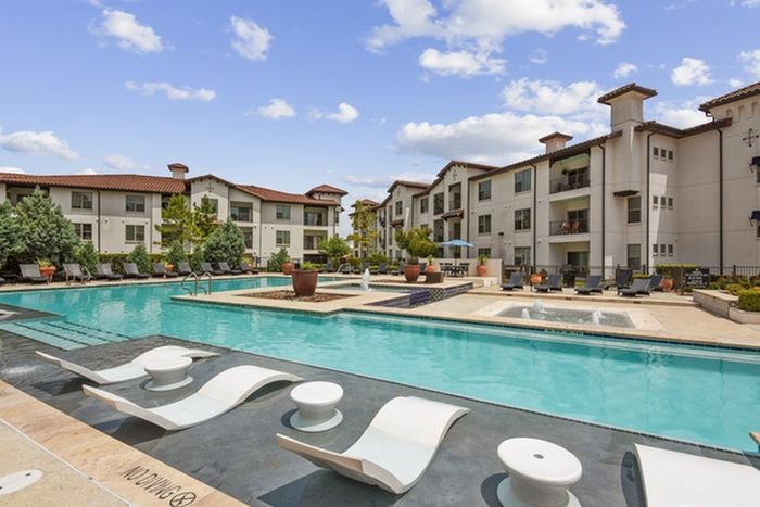 Resort-style pool with ample relaxing seating at Lantower Ambrosio Apartments.